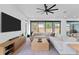 A bright living room with an oversized couch, decorative rug, and sliding glass doors to backyard at 2517 N Riverside Dr, Tampa, FL 33602