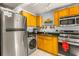 Compact kitchen equipped with stainless steel appliances, wood cabinets, and granite countertops at 3889 Pompano Se Dr # A, St Petersburg, FL 33705