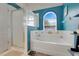 Bright bathroom features a tub with an arch window, a shower, and modern fixtures at 4605 Lisette Cir, Brooksville, FL 34604