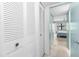 Hallway with louvered closet doors leading to a bedroom with a ceiling fan and window at 4920 Locust Ne St # 116, St Petersburg, FL 33703