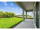 A covered patio overlooking a spacious backyard with beautiful landscaping at 5289 Everlong Dr, Apollo Beach, FL 33572