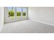 Bedroom with soft gray carpet and three bright windows at 5289 Everlong Dr, Apollo Beach, FL 33572