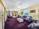 Open-concept living room shows the purple sofa, a decorative screen, with views into the kitchen at 5309 21St S Ave, Gulfport, FL 33707