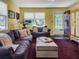 Inviting living room features a comfortable purple sofa, an ottoman, and natural light from a window at 5309 21St S Ave, Gulfport, FL 33707