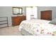 Bedroom featuring floral bedding, carpeted floor, mirror, and wooden dresser at 5581 Salem Square S Dr, Palm Harbor, FL 34685