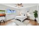 This bedroom offers natural light, wood floors, modern ceiling fan, desk and view of the water at 800 Madonna Blvd # 2, Tierra Verde, FL 33715