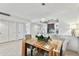 Bright dining room features a modern light fixture, wood table and is adjacent to the living room and kitchen at 800 Madonna Blvd # 2, Tierra Verde, FL 33715