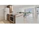 Open-concept living space featuring a modern kitchen, dining area, and comfortable seating with water views at 800 Madonna Blvd # 2, Tierra Verde, FL 33715