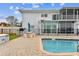 Beautiful pool with outdoor seating adjacent to a modern home with a second-story balcony at 800 Madonna Blvd # 2, Tierra Verde, FL 33715