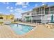 A beautiful pool with stone decking and a modern two-story home in the background offers a luxurious outdoor space at 800 Madonna Blvd # 2, Tierra Verde, FL 33715
