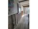 Hallway features partially destroyed walls, gray wood-look floors, and overhead beams at 16108 5Th E St, Redington Beach, FL 33708