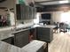 Open-concept kitchen features gray cabinetry, stone countertops, and stainless steel sink at 16108 5Th E St, Redington Beach, FL 33708