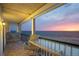 Gulf Coast view of a condo balcony overlooking beach with chairs and glass-topped table at 19450 Gulf Blvd # 401, Indian Shores, FL 33785