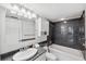 Modern bathroom with marble accents, a bathtub and a sink with white cabinet at 19450 Gulf Blvd # 401, Indian Shores, FL 33785