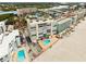 Modern beachfront condo building with a community pool, parking, and stunning coastal views under a bright sky at 19450 Gulf Blvd # 401, Indian Shores, FL 33785