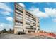 Modern condominium building with private beach access, on-site parking, and panoramic views under a partly cloudy blue sky at 19450 Gulf Blvd # 401, Indian Shores, FL 33785