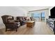 Bright living room features slider doors to a balcony with ocean views and comfortable seating at 19450 Gulf Blvd # 401, Indian Shores, FL 33785