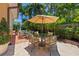 Inviting outdoor patio featuring a dining table under a sun umbrella, surrounded by lush landscaping and a serene atmosphere at 1124 Seville Ne Ln, St Petersburg, FL 33704