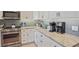 Updated kitchen with granite countertops, stainless steel appliances, and stylish backsplash at 145 Brightwater Dr # 2, Clearwater, FL 33767