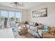 Cozy living room with comfortable seating, a ceiling fan, and sliding glass doors to the balcony at 145 Brightwater Dr # 2, Clearwater, FL 33767
