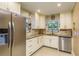 Bright kitchen featuring granite countertops, stainless steel appliances, and tile backsplash at 1611 San Charles Dr, Dunedin, FL 34698