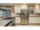 Well-lit kitchen featuring granite countertops, stainless steel refrigerator, and ample storage space at 1611 San Charles Dr, Dunedin, FL 34698