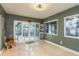 Sun-drenched living room with tiled flooring, sliding glass doors, and a view of the pool at 1611 San Charles Dr, Dunedin, FL 34698