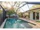 Screened-in pool with patio table set, brick pavers, outdoor space and jacuzzi-style seating at 1611 San Charles Dr, Dunedin, FL 34698