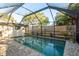 Screened-in pool boasts brick pavers, privacy fence, mature landscaping, and outdoor space at 1611 San Charles Dr, Dunedin, FL 34698