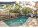 Sparkling pool with enclosure, brick pavers, mature landscaping, and privacy fence at 1611 San Charles Dr, Dunedin, FL 34698