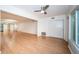 Bright living room featuring wood floors, white walls, and a modern ceiling fan at 2258 World Parkway W Blvd # 8, Clearwater, FL 33763