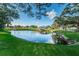 Scenic pond with a wooden gazebo, lush green surroundings, and clear blue sky at 2258 World Parkway W Blvd # 8, Clearwater, FL 33763