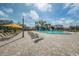 A spacious pool area with lounge chairs, umbrellas, and well-maintained landscaping under a clear sky at 2258 World Parkway W Blvd # 8, Clearwater, FL 33763