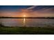 Scenic waterfront view at sunset with grass in foreground and trees in background at 2258 World Parkway W Blvd # 8, Clearwater, FL 33763