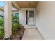 Inviting front porch with column and mature landscaping, leading to the home's entrance at 435 Meadowlark Ln, Palm Harbor, FL 34683