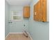Functional laundry room with built-in cabinets, tiled floor, and a window for natural light at 435 Meadowlark Ln, Palm Harbor, FL 34683