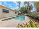 Backyard featuring pool, patio, tropical plants, and a fenced perimeter, perfect for outdoor enjoyment and privacy at 435 Meadowlark Ln, Palm Harbor, FL 34683