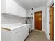 Practical utility room featuring tiled walls, ample counter space, and a water heater at 435 Meadowlark Ln, Palm Harbor, FL 34683