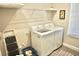 Bright laundry room features a modern washer and dryer, ample shelving, and a convenient step stool at 5426 Rushmere Ct, Palmetto, FL 34221