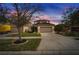 Two-story home with a large driveway, well-kept lawn and mature landscaping under a dramatic sunset sky at 12610 Geneva Glade Dr, Riverview, FL 33578
