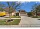 Two-story home with a large driveway, well-kept lawn and mature landscaping under a sunny sky at 12610 Geneva Glade Dr, Riverview, FL 33578
