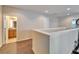 Hallway features wood-look tile flooring, a half wall, and a door to the bathroom at 12610 Geneva Glade Dr, Riverview, FL 33578