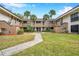 Exterior courtyard view of updated condo building featuring well-maintained landscaping and mature palm trees at 2700 Nebraska Ave # 3-201, Palm Harbor, FL 34684