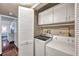 Efficient laundry room with a washer, dryer, and built-in cabinets for ample storage at 2700 Nebraska Ave # 3-201, Palm Harbor, FL 34684