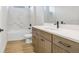 Bright bathroom features marble tile shower, modern vanity with a solid surface countertop, and wood-look flooring at 5211 Lake Venice Dr, Wimauma, FL 33598