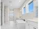 A modern bathroom with white marble floors, double sink vanities, and a large soaking tub at 5211 Lake Venice Dr, Wimauma, FL 33598