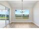 Dining room with a modern chandelier and sliding doors opening to an outdoor water view at 5211 Lake Venice Dr, Wimauma, FL 33598