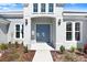 Elegant entryway featuring a double door, decorative lights, and well-kept landscaping at 5211 Lake Venice Dr, Wimauma, FL 33598
