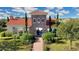 View of exterior community center with red roof and tower and manicured landscaping at 5211 Lake Venice Dr, Wimauma, FL 33598