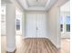 Open foyer area featuring a double door entrance, tray ceiling, and neutral paint at 5211 Lake Venice Dr, Wimauma, FL 33598
